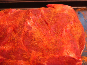 Adding the rub to the pork roast.